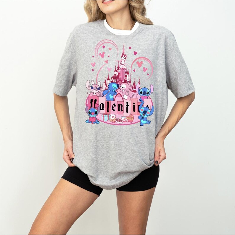 a woman wearing a gray shirt with a pink castle on it