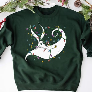 May include: A dark green sweatshirt with a white ghost-like figure with a candy cane in its mouth. The figure is surrounded by colorful Christmas lights.
