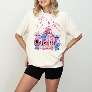 a woman wearing a white shirt with a pink castle on it