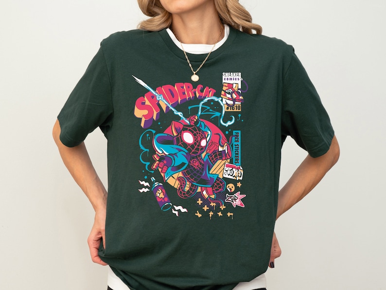 K&ouml;nnte beinhalten: Ein dunkelgr&uuml;nes T-Shirt mit einem Grafikdruck eines Comic-Spider-Man-Charakters in einem rot-schwarzen Anzug. Die Grafik enth&auml;lt auch den Text "SPIDER-CAT" und "FREE STICKERS".