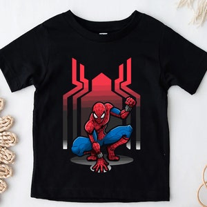 May include: Black t-shirt with a red and blue Spider-Man graphic. The graphic shows Spider-Man in a crouching pose with a red and blue suit and a red spider symbol on his chest. The background of the graphic is a red and black web design.