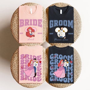 May include: Four t-shirts with wedding-themed designs. Two pink shirts say "BRIDE" with Ariel graphics, and two black shirts say "GROOM" with Prince Eric graphics. All shirts include the year "2024". The shirts are on a woven surface.