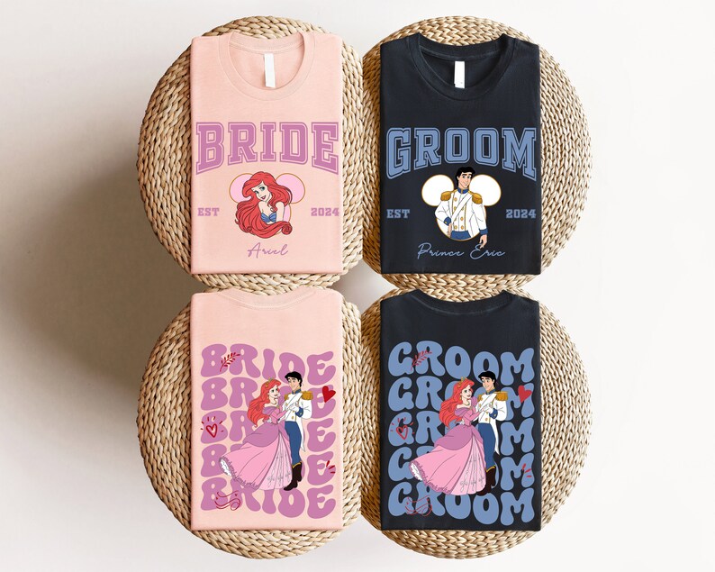 May include: Four t-shirts with wedding-themed designs. Two pink shirts say "BRIDE" with Ariel graphics, and two black shirts say "GROOM" with Prince Eric graphics. All shirts include the year "2024". The shirts are on a woven surface.