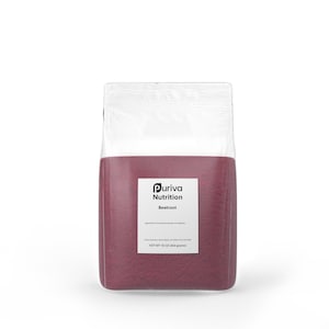 May include: A clear plastic bag filled with a deep red powder. The bag has a white label with the text "Puriva Nutrition Beetroot" and "NET WT 16 OZ (454 grams)". The bag is sealed at the top.