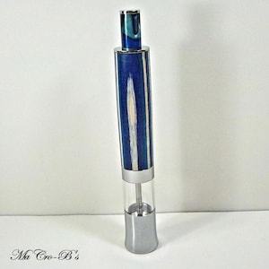 May include: A blue and white wood pepper mill with a silver top and base. The mill is made of wood with a blue and white striped pattern.
