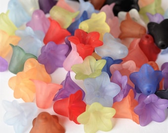 May include: A collection of colorful plastic flower-shaped beads. The beads are translucent and come in a variety of colors, including red, blue, green, yellow, orange, and purple.