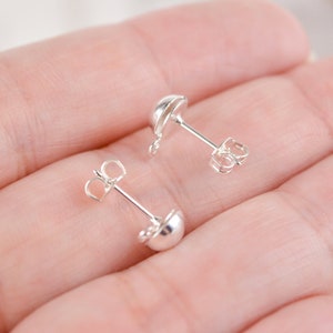 May include: A pair of silver earring posts with a round ball at the end. The posts are designed to be used with a variety of earring findings.