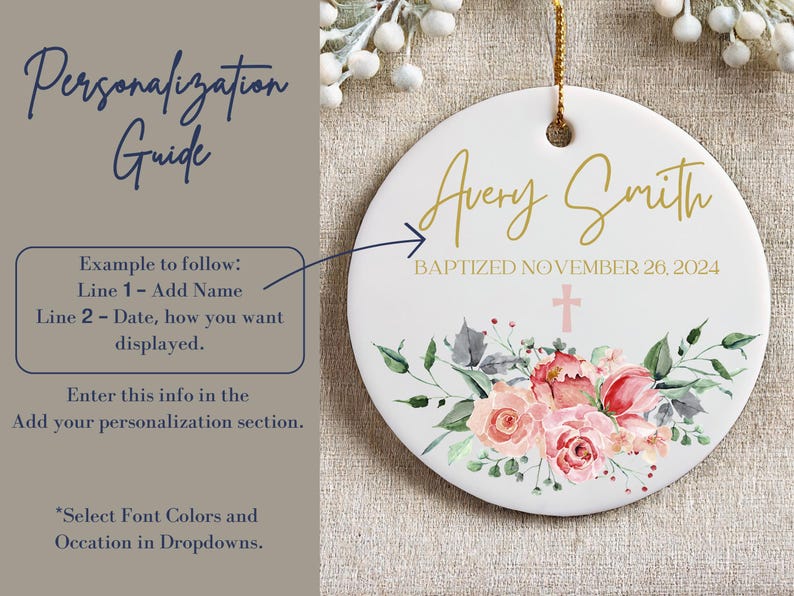 May include: A white ceramic ornament with a floral design and gold lettering. The ornament says "Avery Smith Baptized November 26, 2024".