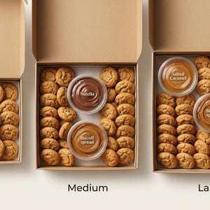 May include: Three open cardboard boxes labeled Small, Medium, and Large, filled with round cookies. The small box contains one Chocolate Fudge dip. The medium box holds Nutella and Biscoff spread. The large box includes Salted Caramel, Biscoff spread, and Chocolate Fudge.