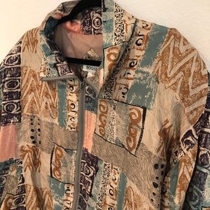 May include: A vintage jacket with a zipper closure and a colorful abstract print featuring brown, blue, pink, and black geometric shapes. The jacket has the word "BOGAF" printed on the front.