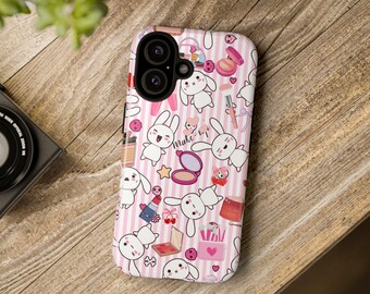 May include: Pink and white phone case with a pattern of bunnies, makeup, and the words "Make Up".