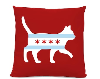 May include: Red throw pillow with a white silhouette of a cat wearing a Chicago flag design. The cat is facing right and has a long tail.