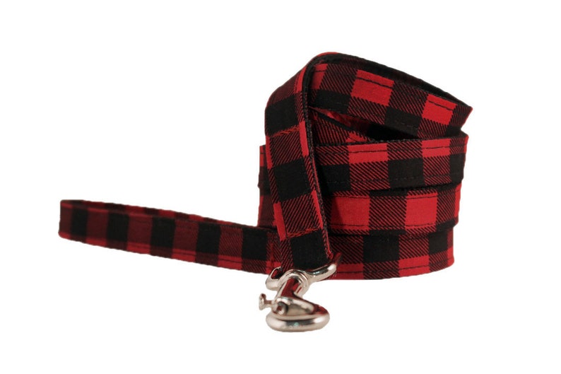 May include: Red and black plaid dog leash with a silver clip.
