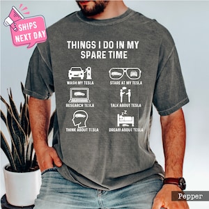May include: A gray t-shirt with the text "Things I do in my spare time" and a list of activities related to Tesla cars. The activities include washing, staring at, researching, talking about, thinking about, and dreaming about Tesla cars.