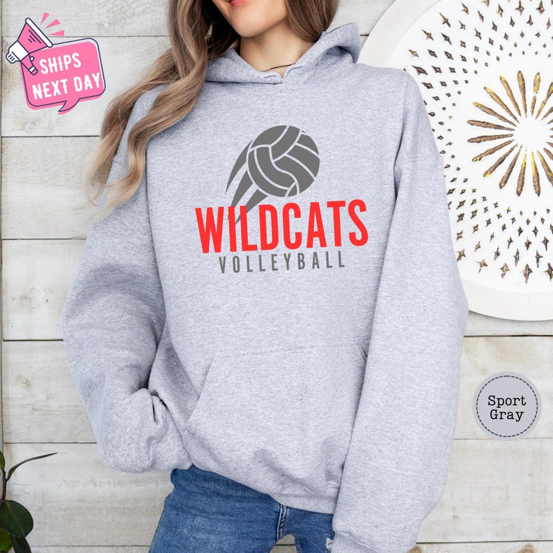 a woman wearing a sweatshirt with the words wildcats volleyball on it