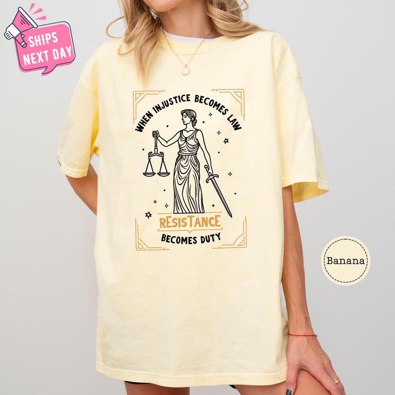 a woman wearing a yellow t - shirt with a lady justice t - shirt on