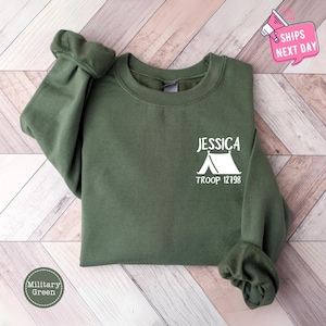 a green sweatshirt with a camper's tent on it