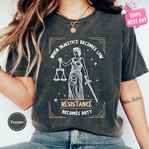 a woman wearing a t - shirt that says, when justice becomes law, resistance