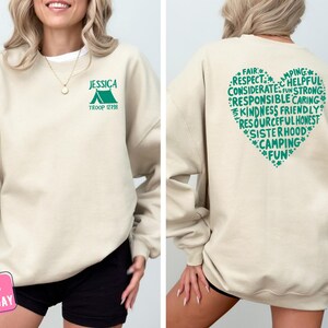a woman wearing a sweatshirt with the words camping printed on it