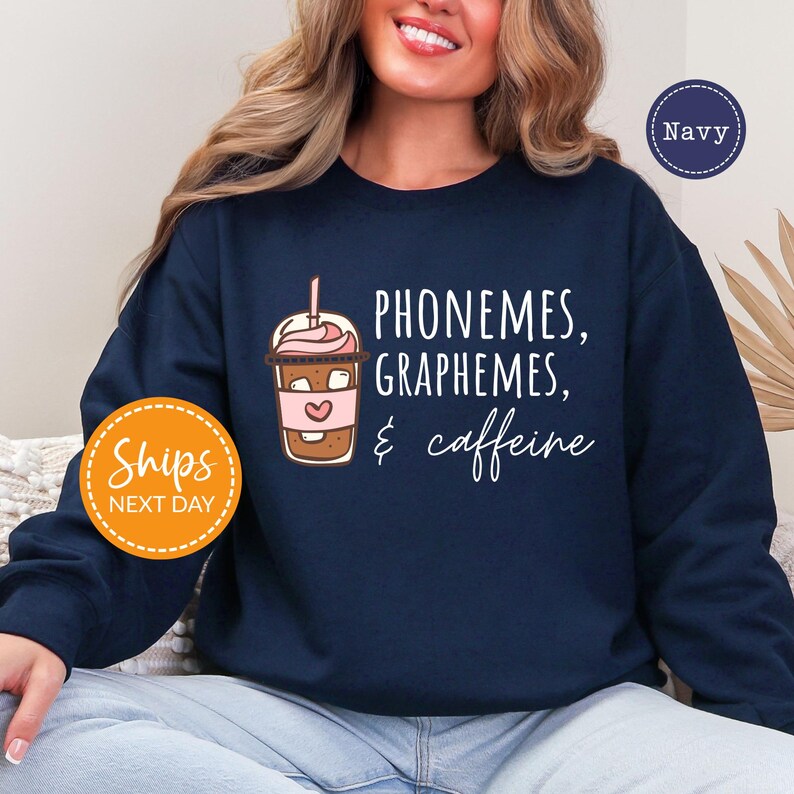 A woman wearing a navy blue sweatshirt with text and an illustration of a coffee drink.