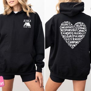 a woman wearing a black hoodie with white writing on it