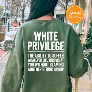 a person wearing a green sweatshirt with white text on the back. The text reads "WHITE PRIVILEGE" and "THE ability to suffer whatever life throws at you without Blaming another Ethnic group".
