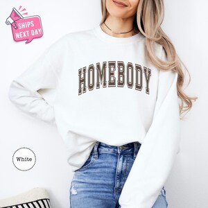 a woman wearing a sweatshirt that says homeboy
