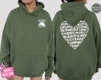 May include: Green hooded sweatshirt with a white tent graphic and the text "JESSICA TROOP 12798" on the front. The back of the sweatshirt has a white heart with the text "FAITH, RESPECT, CONSIDERATE, FUN, STRONG, RESPONSIBLE, CARING, KINDNESS, FRIENDLY, RESOURCEFUL, HONEST, SISTERHOOD, CAMPING, FUN" inside.