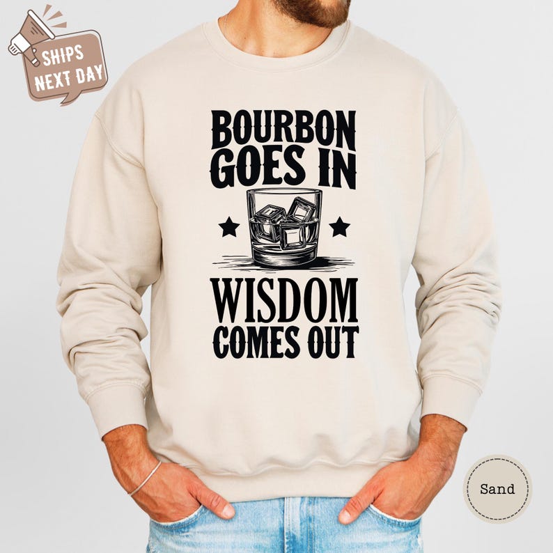 a man wearing a sweatshirt that says bourbon goes in wisdom comes out