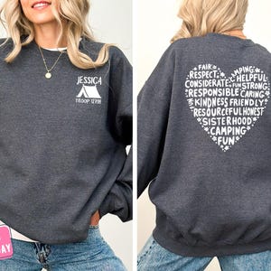 a woman wearing a sweatshirt with a heart on it