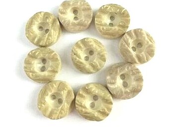 Puede incluir: Diez botones beige con un diseño texturizado en relieve. Cada botón tiene dos agujeros.