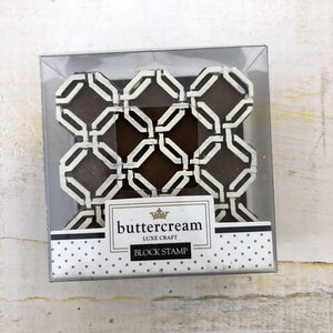 Op de afbeelding: Een bruine en witte geometrische blokstempel in een transparante plastic verpakking. De stempel is gelabeld met "buttercream LUXE CRAFT BLOCK STAMP".