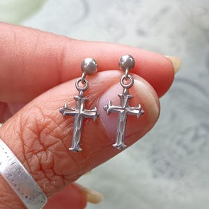Silver cross dangle earrings.