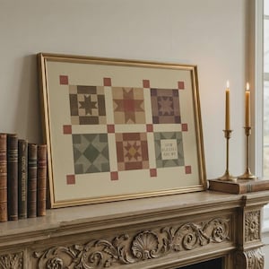 May include: A framed rectangular print featuring a grid of six quilt-style blocks in muted earth tones. The blocks display geometric star patterns, with one block containing the text 'HOW BLESSED ARE WE' in a simple, dark, sans-serif font.