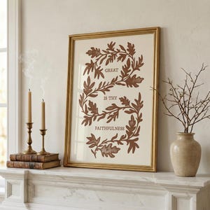 Könnte beinhalten: Ein gerahmtes, rechteckiges Wandbild mit cremefarbenem Hintergrund und einer braunen botanischen Rankenillustration in S-Form. Der Text GREAT IS THY FAITHFULNESS ist in Braun in der Mitte des Rankenmotivs in einem goldenen Rahmen gedruckt.