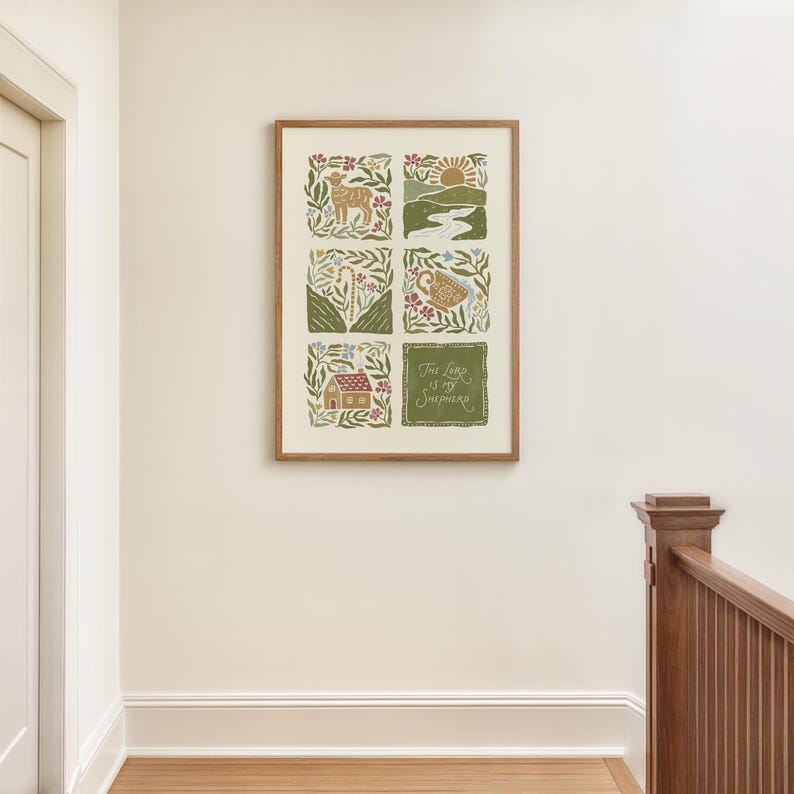 May include: A framed art print with six illustrated squares depicting nature and religious themes. The artwork includes a lamb, a sunrise, a river, a cup, a house, and the text "The Lord is my Shepherd". The frame is a light brown colour.
