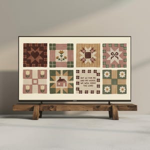 May include: A framed print featuring a patchwork quilt design with various patterns and colors, including hearts, flowers, and stars. The text "BUT AS FOR ME AND MY HOUSE, WE WILL SERVE THE LORD" is displayed. The print is displayed on a wooden stand.