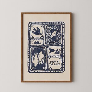 Könnte beinhalten: Ein gerahmter Kunstdruck mit cremefarbenem Hintergrund und marineblauen Vogelillustrationen. Das Kunstwerk ist in sechs rechteckige Abschnitte unterteilt, die jeweils eine andere Vogelzeichnung zeigen. Der Text "LOOK AT THE BIRDS" befindet sich unten.