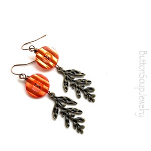 May include: Orange and white striped button earrings with bronze leaf accents.