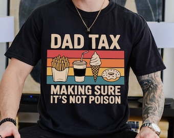May include: Black t-shirt with the text "DAD TAX MAKING SURE IT'S NOT POISON" and a graphic of fries, a drink, ice cream, and a donut in a retro color scheme. The shirt is a casual wear item.