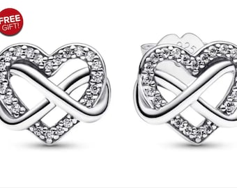 Puede incluir: Un par de pendientes de plata con un diseño de símbolo de infinito en forma de corazón. Los pendientes están adornados con pequeñas piedras de circonita cúbica transparentes.