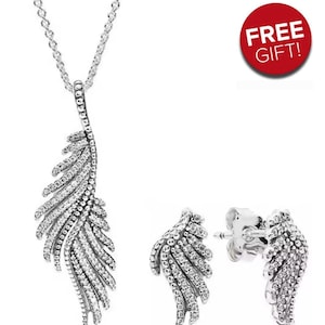 May include: A silver necklace with a feather-shaped pendant and matching stud earrings. The pendant and earrings are adorned with small, sparkling stones. A red circle with the text "FREE GIFT!" is in the upper right corner of the image.