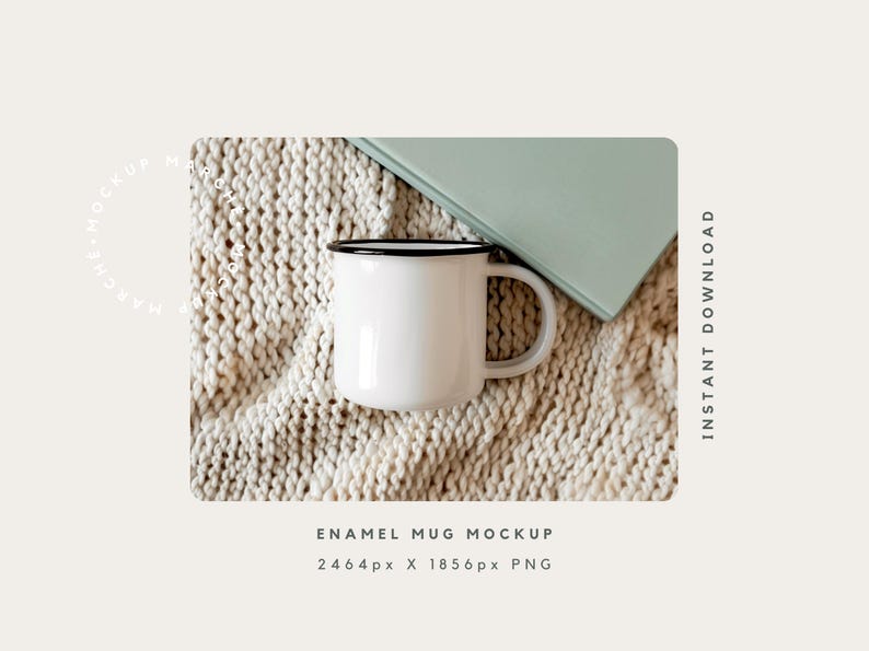 May include: White enamel mug with a black rim sitting on a beige knitted blanket. The mug is empty and has a handle. A green book is partially visible in the background.
