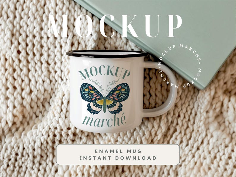 May include: White enamel mug with a black rim and handle. The mug has a butterfly graphic with the text "MOCKUP march&eacute;" printed on it. The mug is sitting on a white knitted blanket.