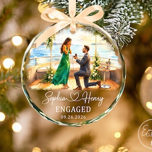 Puede incluir: Un adorno navide&ntilde;o de cristal redondo y facetado con una ilustraci&oacute;n impresa de una propuesta de matrimonio en un barco. El texto dice Sophia, un icono de coraz&oacute;n, Henry, ENGAGED y 09.26.2026. Una cinta beige claro est&aacute; atada en la parte superior.