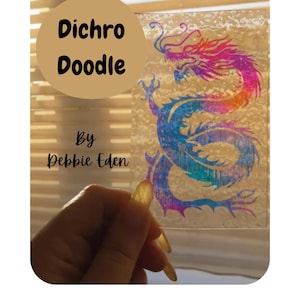 May include: A dichroic glass etching featuring a colorful dragon design. The dragon is rendered in shades of blue, purple, and pink. The text "Dichro Doodle" and "By Debbie Eden" are also visible. The technique is described as "Dichroic glass etching technique".