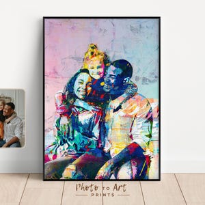 May include: A framed art print featuring a family portrait with vibrant, abstract colors. The artwork depicts a smiling family of three, with the text "Photo to Art Prints" at the bottom. A smaller, unframed photo is also visible.