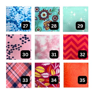 May include: A grid of nine fabric swatches labeled 27 through 35. Patterns include blue tie-dye, floral, stars on mint, small flowers on pink, pink tie-dye, red chevron, pink plaid, yellow and orange leaves on magenta, and orange topographic lines.