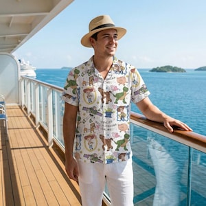 May include: A short-sleeved button-down shirt with a white background and a colorful pattern featuring characters from the Toy Story movie. The person in the image is also wearing a straw hat and white pants.