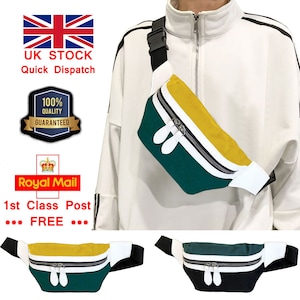 Pode incluir: Uma pochete listrada em verde, amarelo e branco com um zíper branco e uma alça preta. A pochete é mostrada sendo usada por uma pessoa. A imagem também mostra duas pochetes adicionais, uma em verde e preto e outra em amarelo e verde.